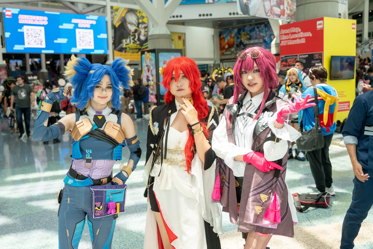 Three cosplayers in elaborate character costumes posing in the concourse at Anime Expo, Los Angeles Convention Center
