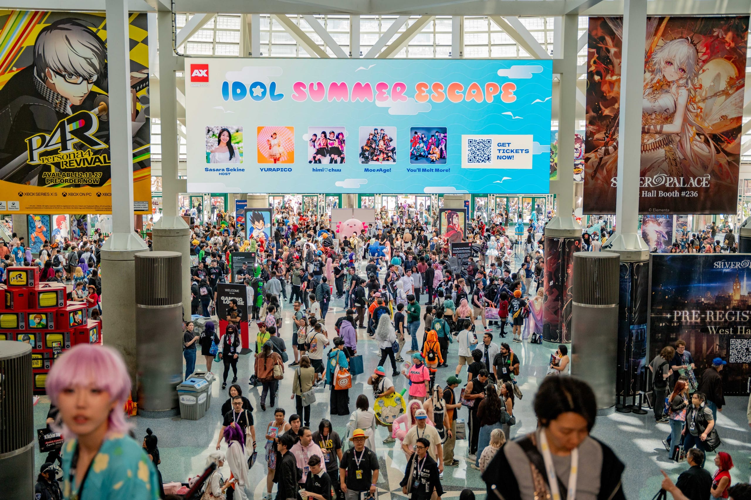 A massive crowd filling the Anime Expo show floor beneath convention banners at the Los Angeles Convention Center, shot by a trade show photographer in Los Angeles