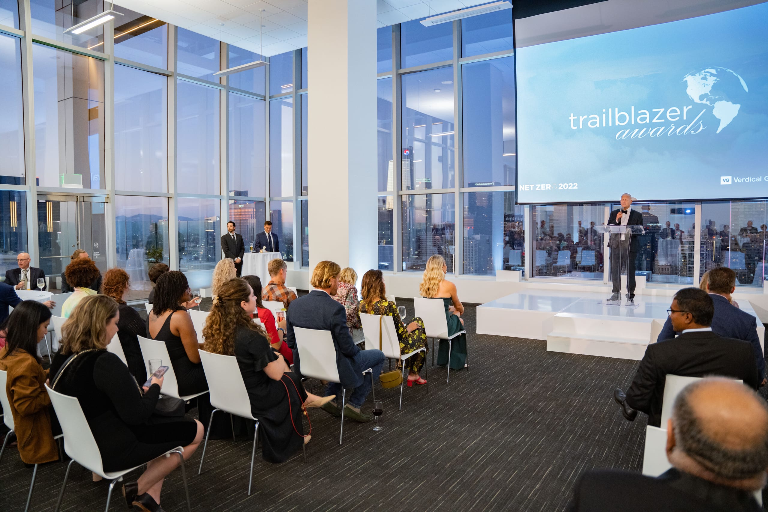 A corporate awards ceremony in a glass-walled venue in downtown Los Angeles