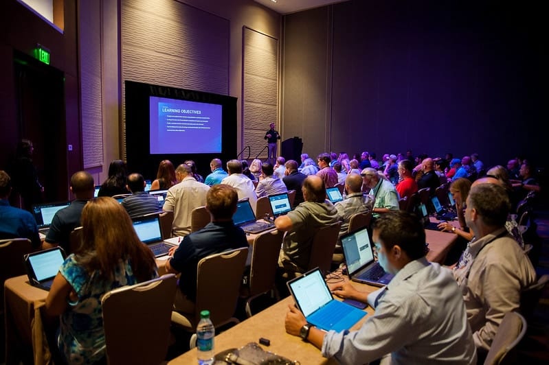 Attendees working on laptops during a corporate conference breakout session