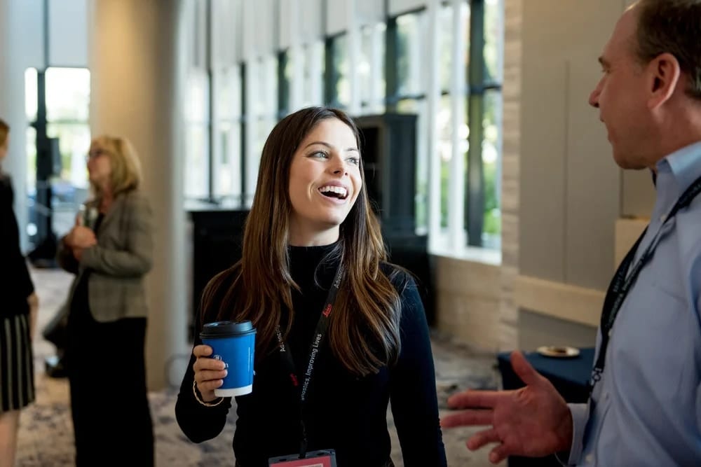 Two attendees talking over coffee between sessions at a corporate conference