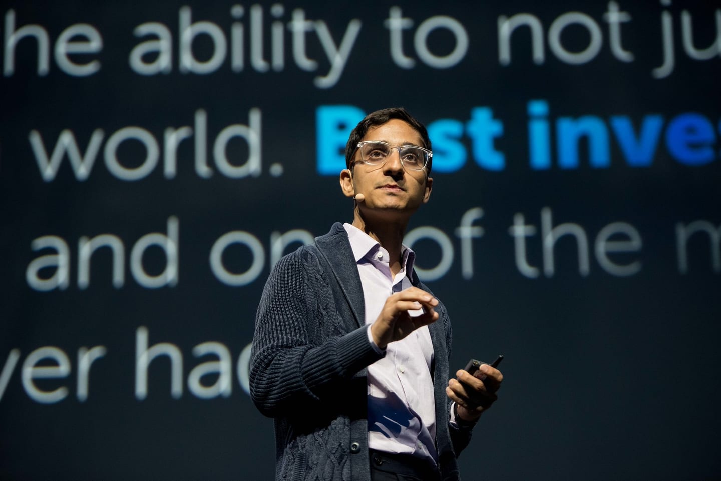 Speaker presenting on stage with large projected text behind him at the 2U conference in Las Vegas