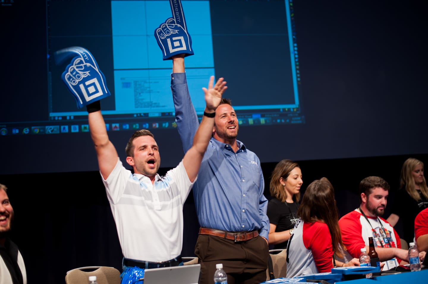 A team cheering with a foam finger raised during a corporate team-building breakout session