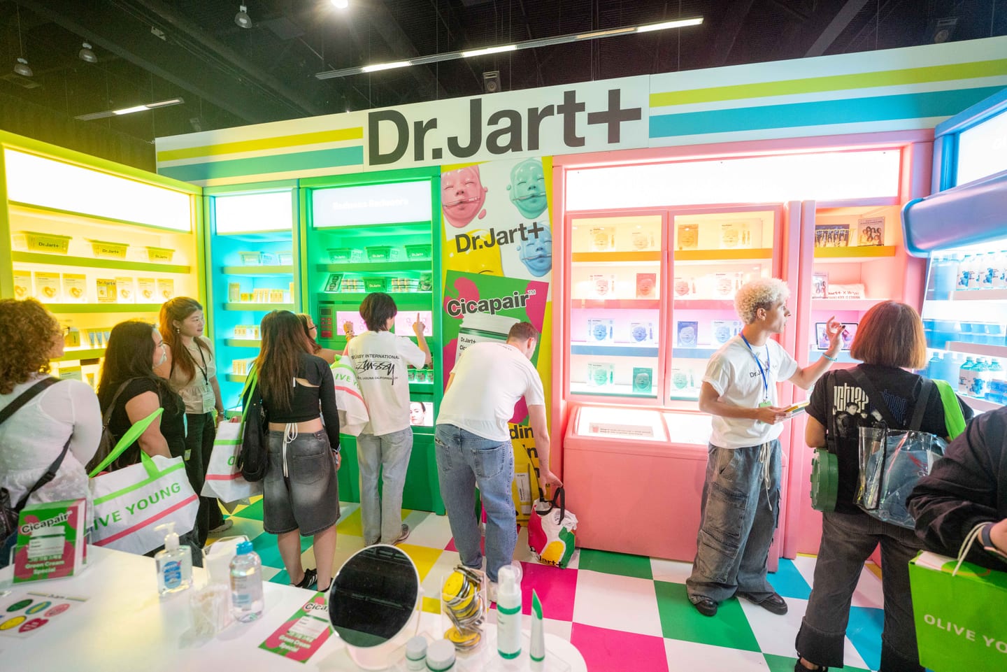 Attendees shopping the colorful Dr. Jart+ and Olive Young K-beauty booth on the KCON LA convention floor
