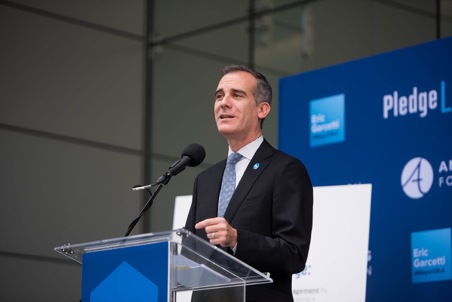 Los Angeles Mayor Eric Garcetti speaking at a podium at the Pledge LA launch with the Annenberg Foundation