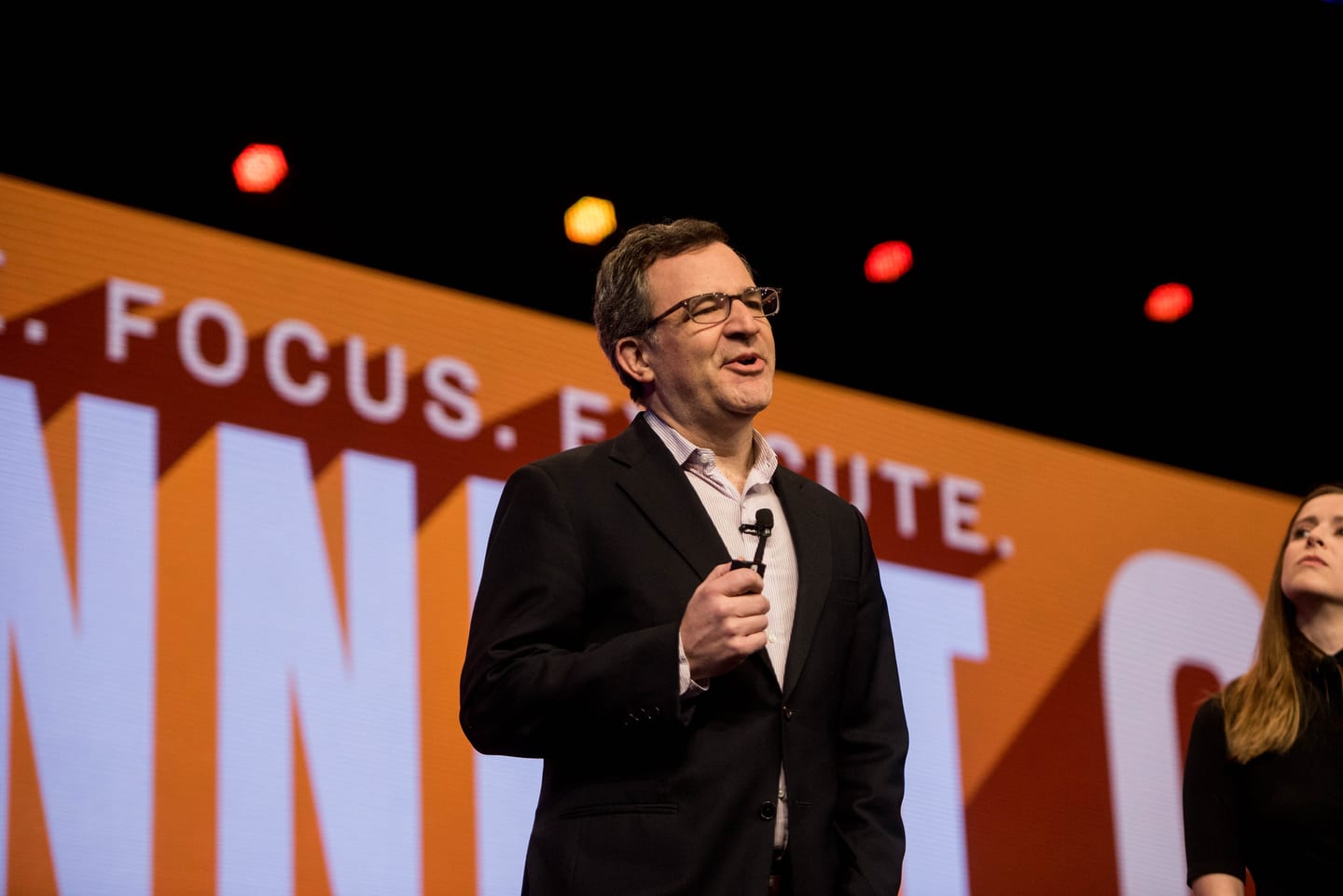 A speaker delivering a keynote on stage in front of a bold graphic screen at the Inman conference in New York