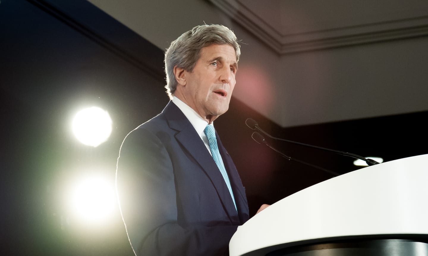 Former U.S. Secretary of State John Kerry delivering a keynote address at a podium