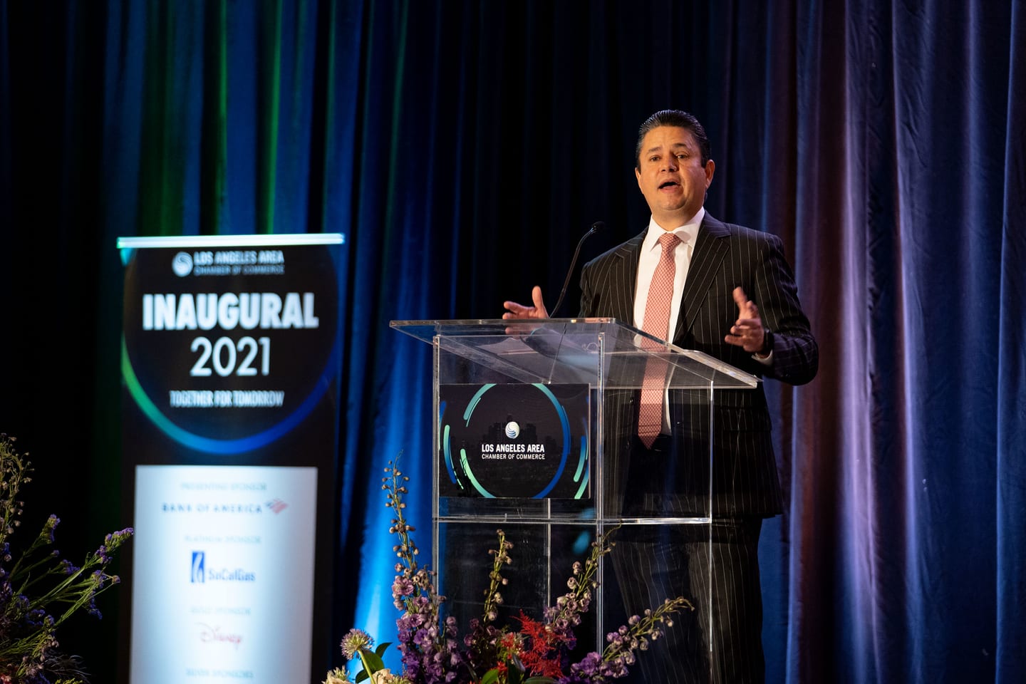 A speaker at the Los Angeles Area Chamber of Commerce podium during the Inaugural 2021 keynote, shot by a conference photographer in Los Angeles