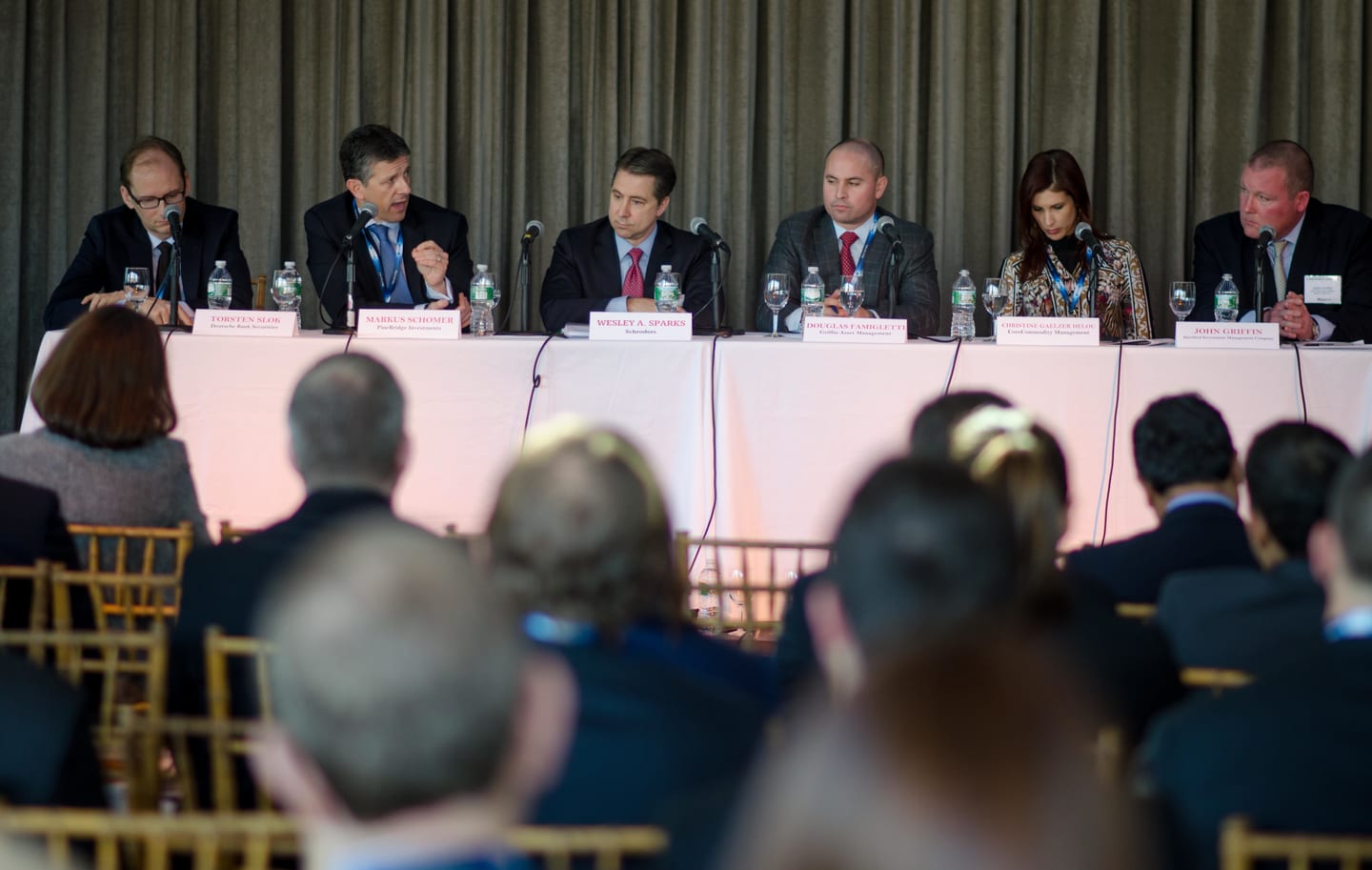 Panelists seated at a long table on stage during a Markets Media finance conference in New York, audience in the foreground