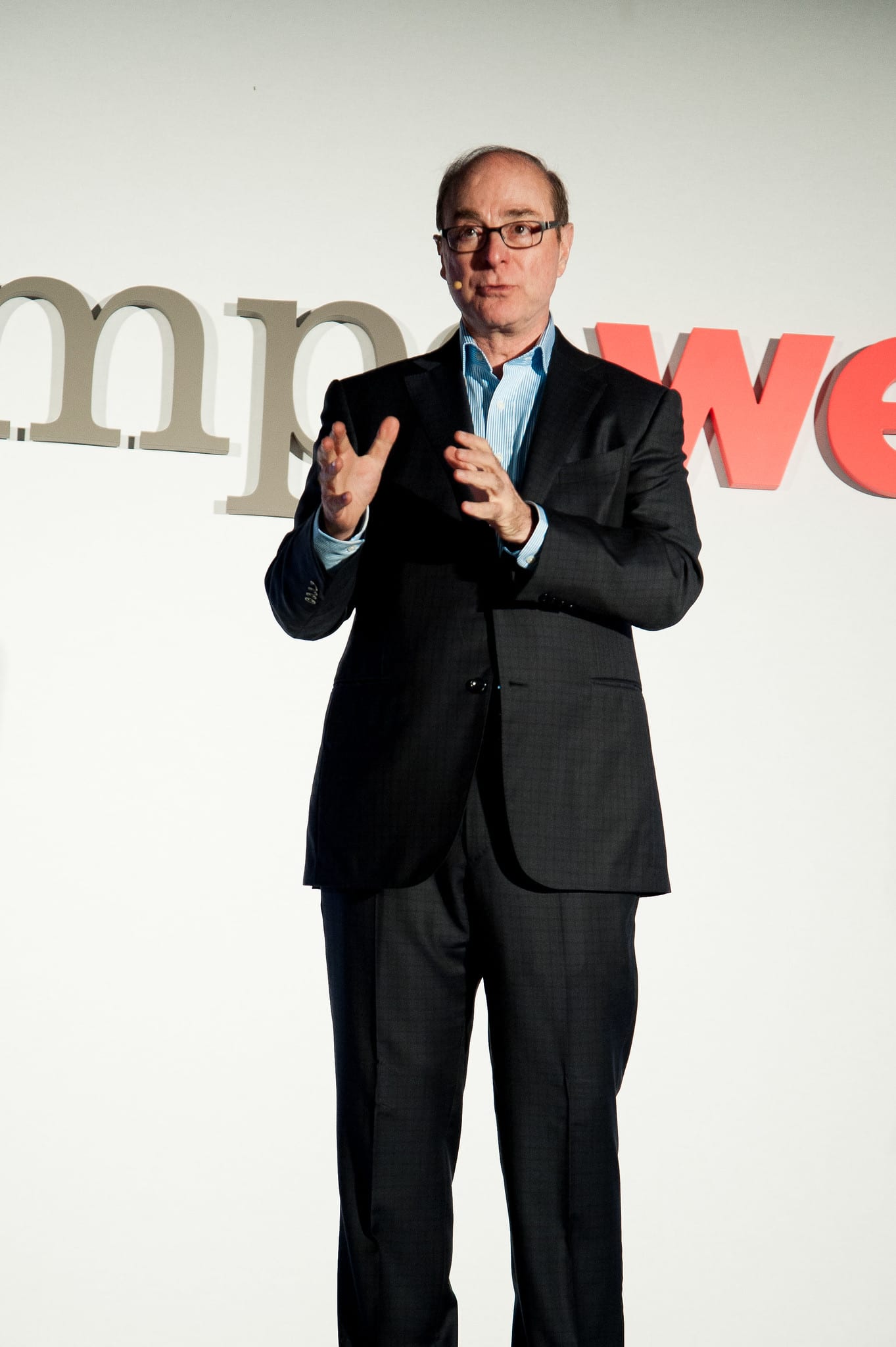 A speaker gesturing on stage in front of a large Empower sign at a Northwestern University keynote