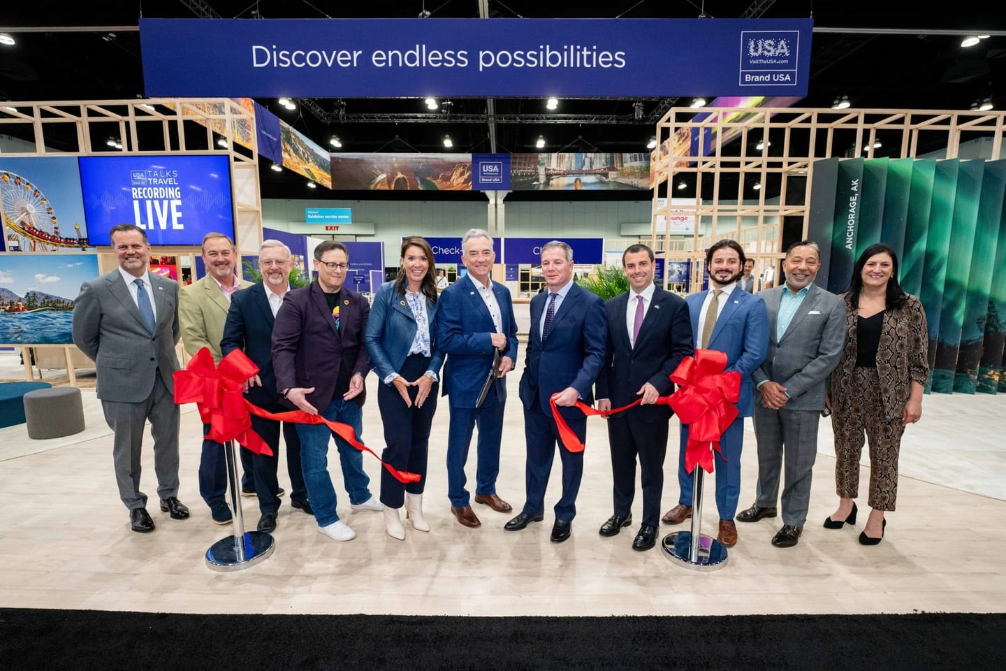 Executives cutting a red ribbon on the U.S. Travel trade show floor in Orlando